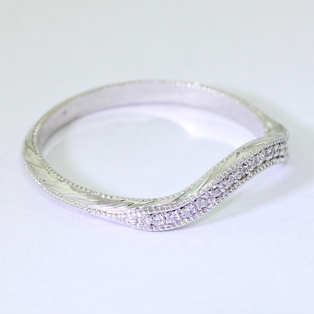 The 14k white gold shadow band features a band of bead-set diamond melee surrounded by an engraved wheat leaf pattern and milgrain.
