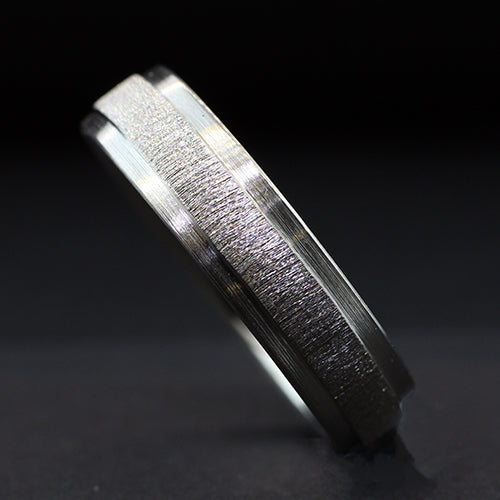 Fabricated from palladium the focal point of this ring is the bright diamond cut raised center, framed on both sides by dropped outer edges. This design creates a striking contrast, accentuating the raised center and adding depth to the band.