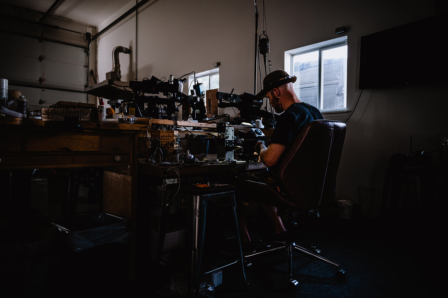 Master jeweler working behind the microscope to craft custom vintage inspired jewelry.