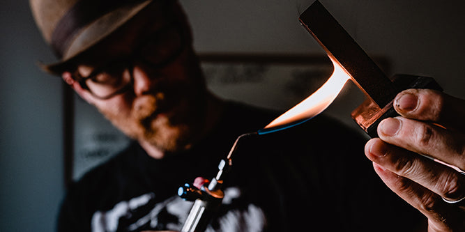 Our jeweler uses a torch to heat an ingot, preparing to pour molten metal for fabrication.