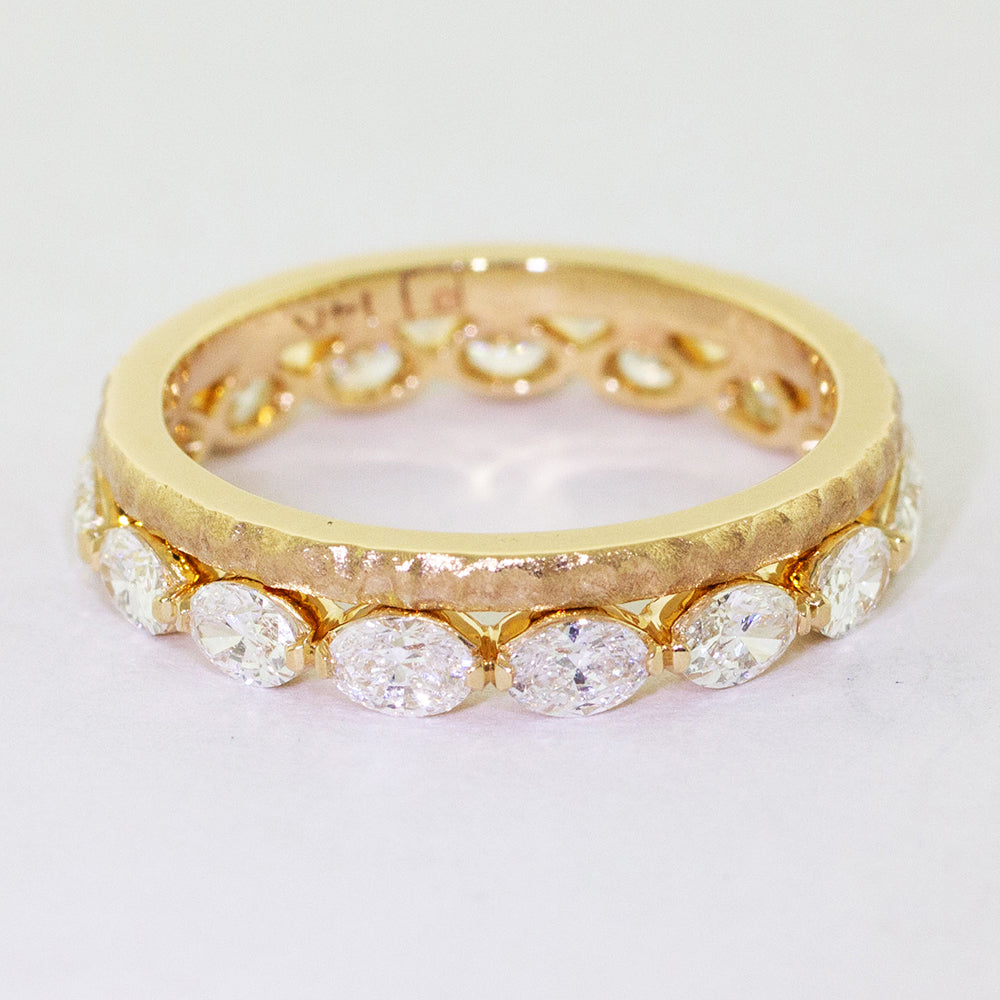 Custom 14k yellow gold matching diamond eternity wedding band boasts fifteen bezel-set diamonds set in an east-west direction.