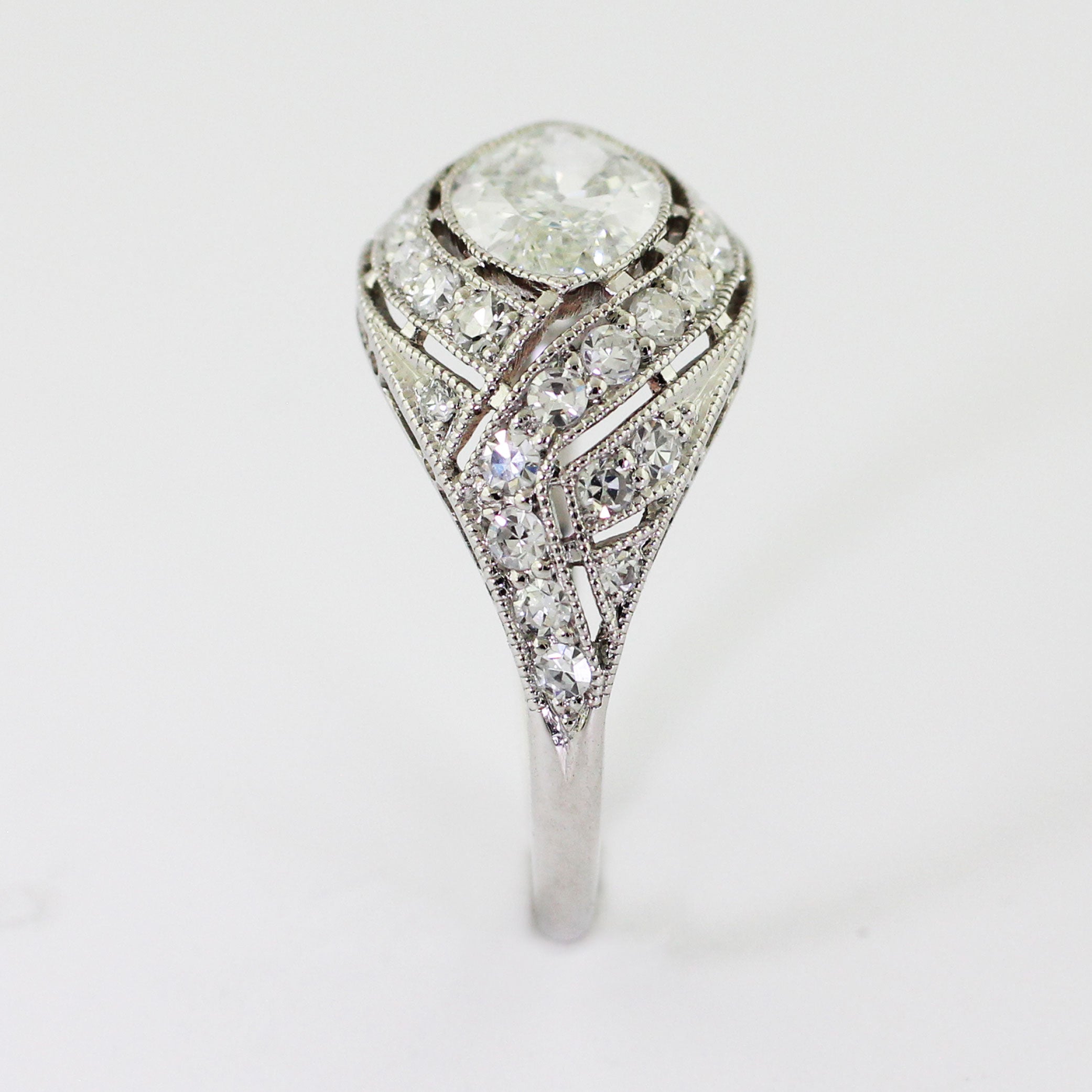 Custom platinum Art Deco ring featuring a marquise center diamond set in an illusion setting with milgrain detailing and bead-set accent diamonds.