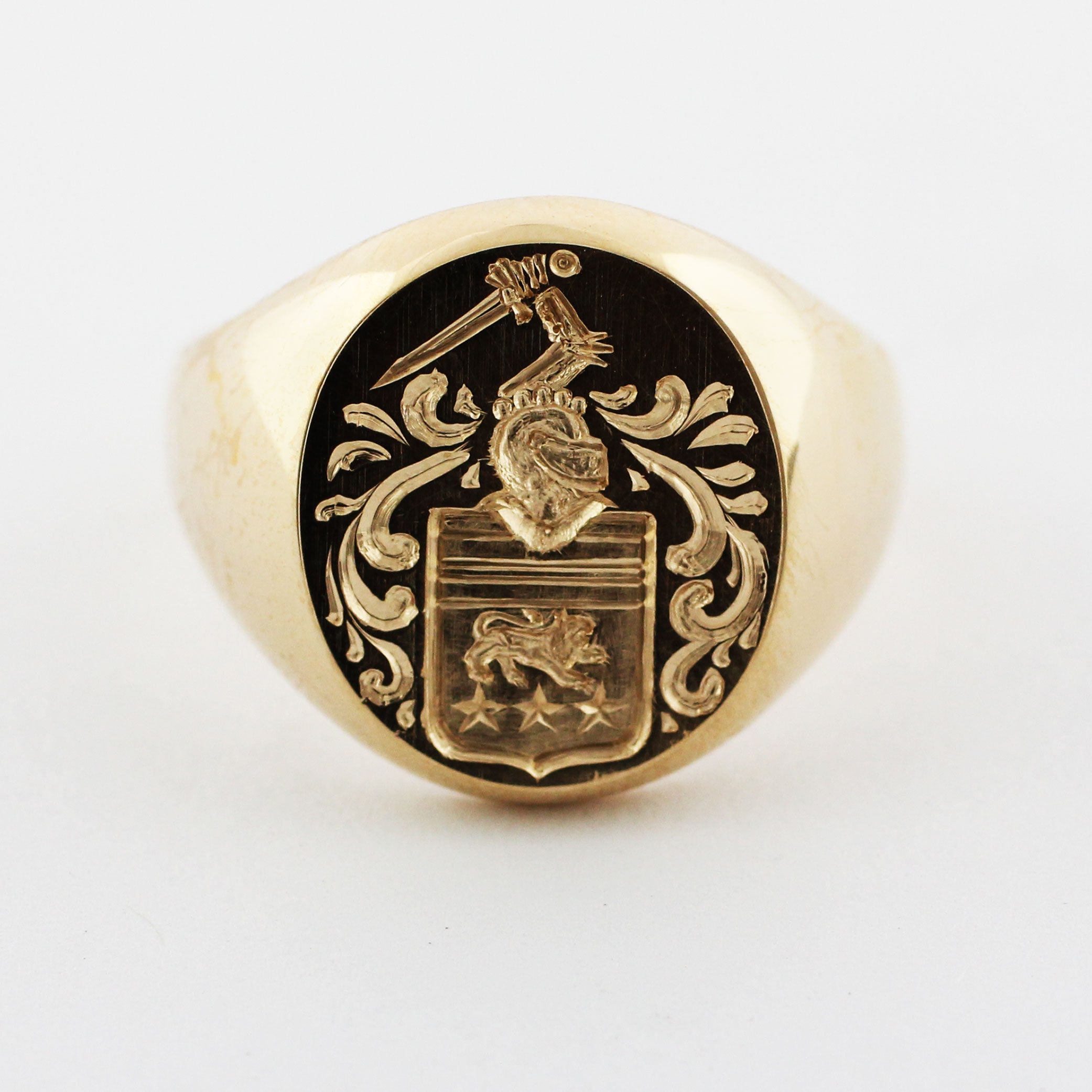 Custom 14-karat yellow gold signet ring proudly displays a meticulously crafted intaglio family crest.