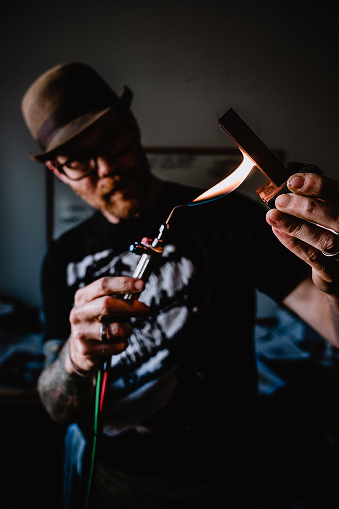 Our jeweler uses a torch to heat an ingot, preparing to pour molten metal for fabrication.