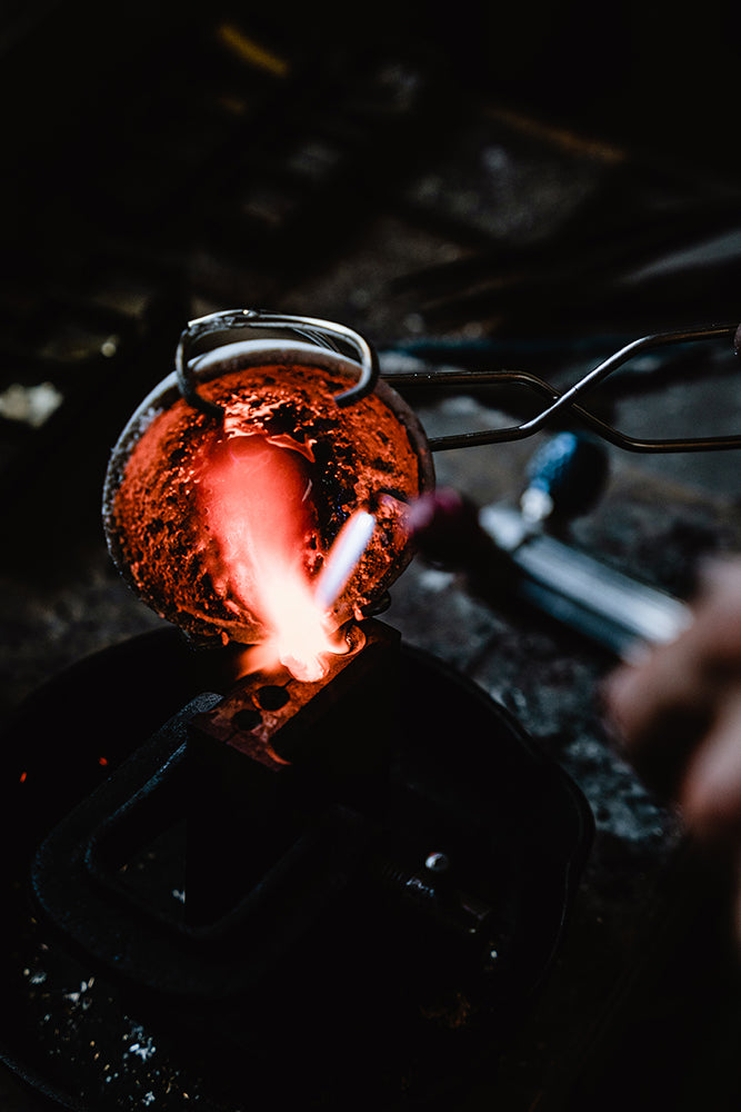 Our jeweler carefully pours molten metal into a mold to create an ingot.