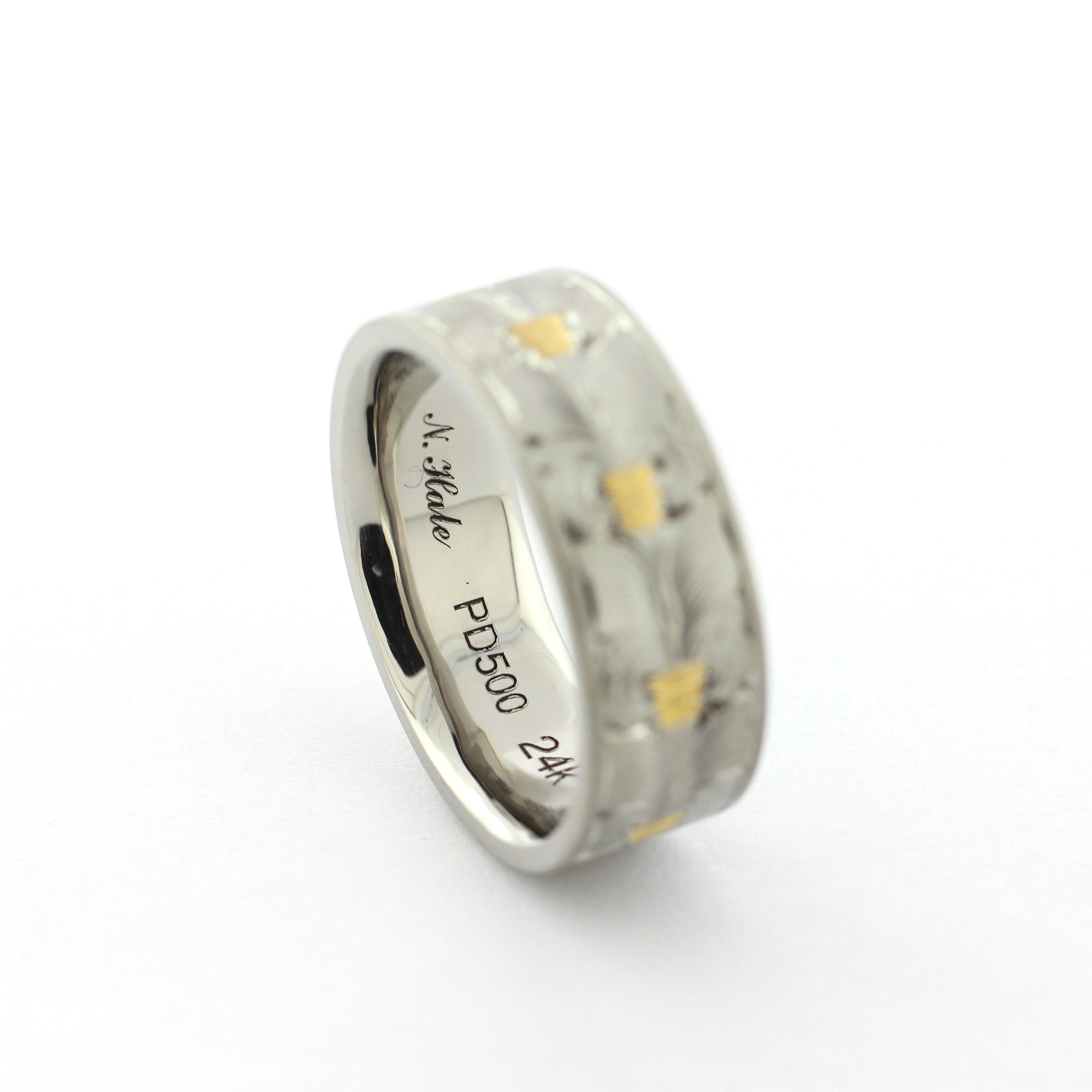 The Colt hand-engraved PD500 palladium band with wheat leaf-inspired engraving and gold inlay accents.