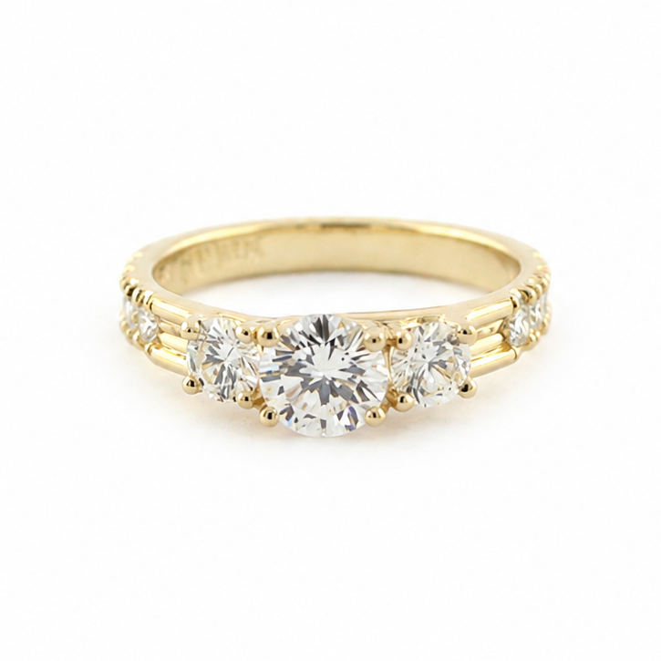 Smith three-stone diamond ring in 14k yellow gold with fishtail-set diamond melee along the side shanks.