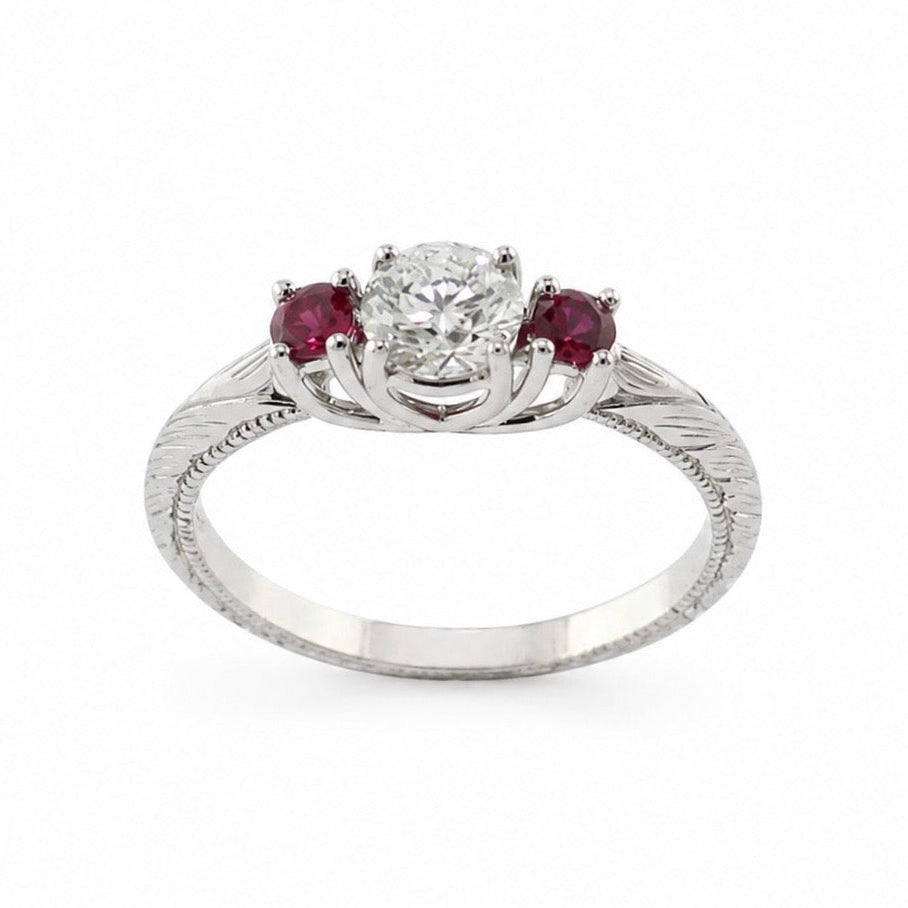 Evangeline platinum trellis ring with a 3/4 carat round brilliant diamond, pigeon blood ruby side stones, hand engraving, and milgrain rail.