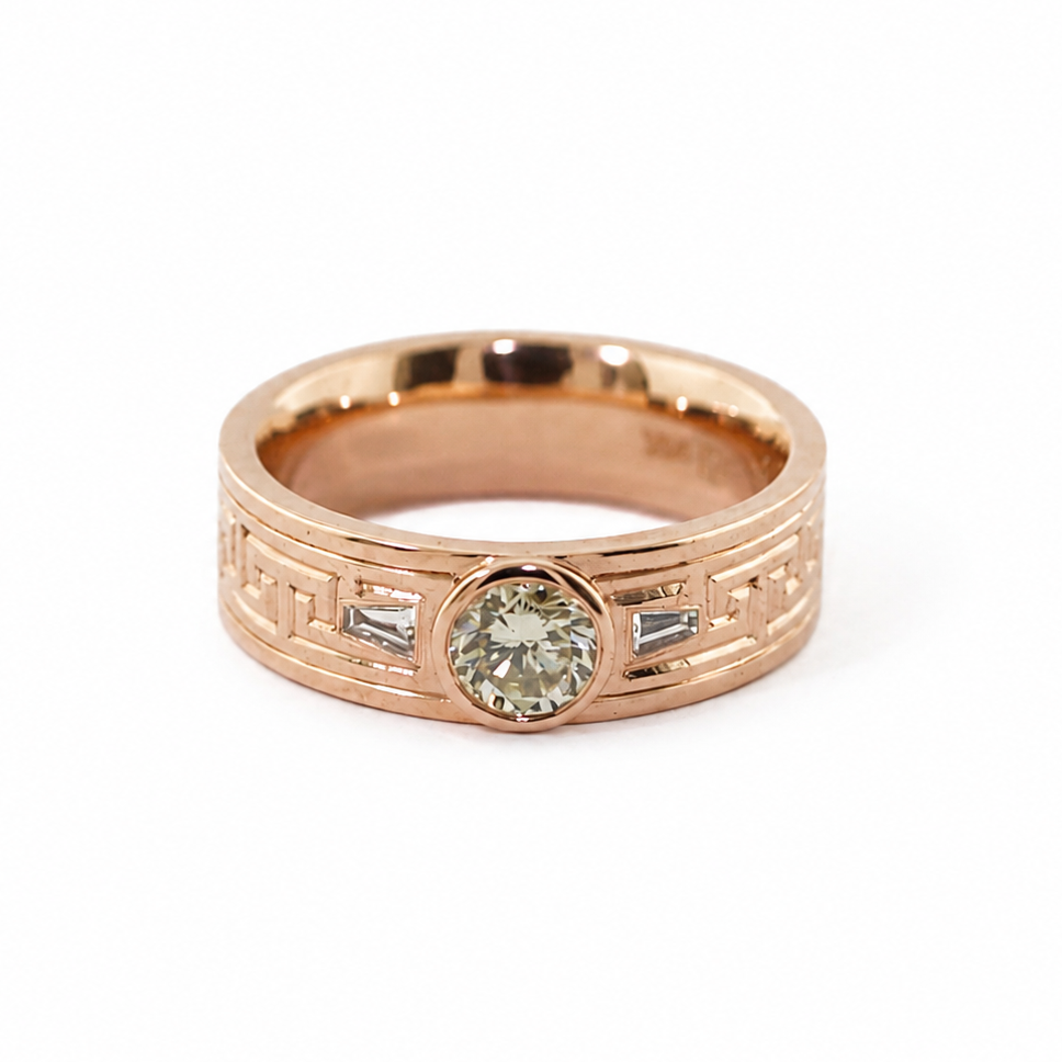 Peterman diamond ring with a round brilliant cut center stone, baguette side stones, and hand-engraved Greek key pattern.